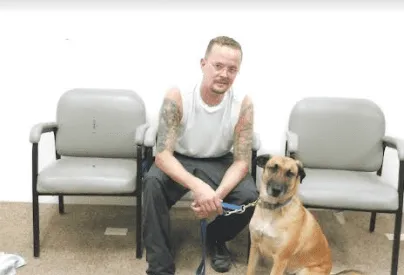 Geoffrey Banks, currently incarcerated in Ohio, works with a service dog in training.